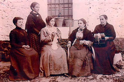 Amparo, que está bordando un paño, aparece junto a estas señoras a las que instruía en su propia casa